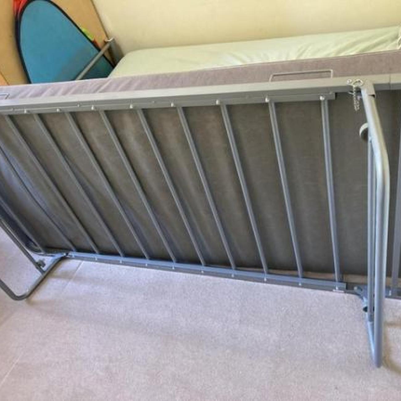 Single metal bed with folding single trundle bed on legs
