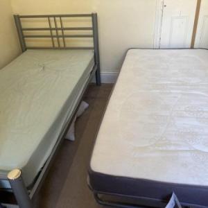 Single metal bed with folding single trundle bed on legs