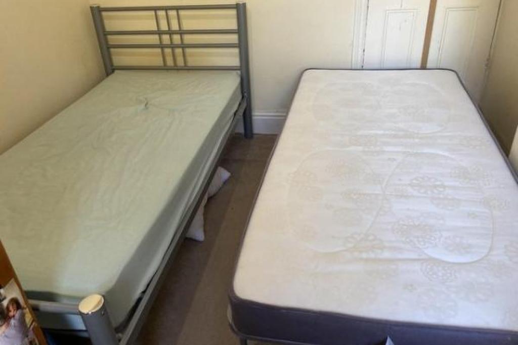 Single metal bed with folding single trundle bed on legs