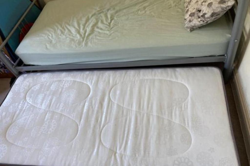 Single metal bed with folding single trundle bed on legs