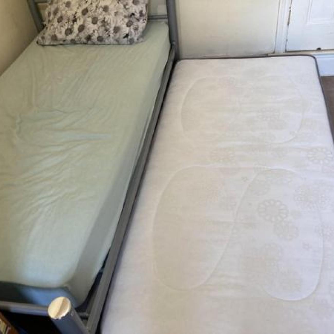 Single metal bed with folding single trundle bed on legs