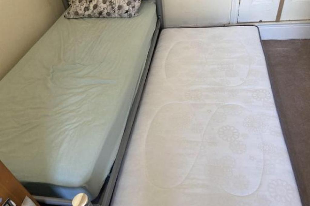 Single metal bed with folding single trundle bed on legs